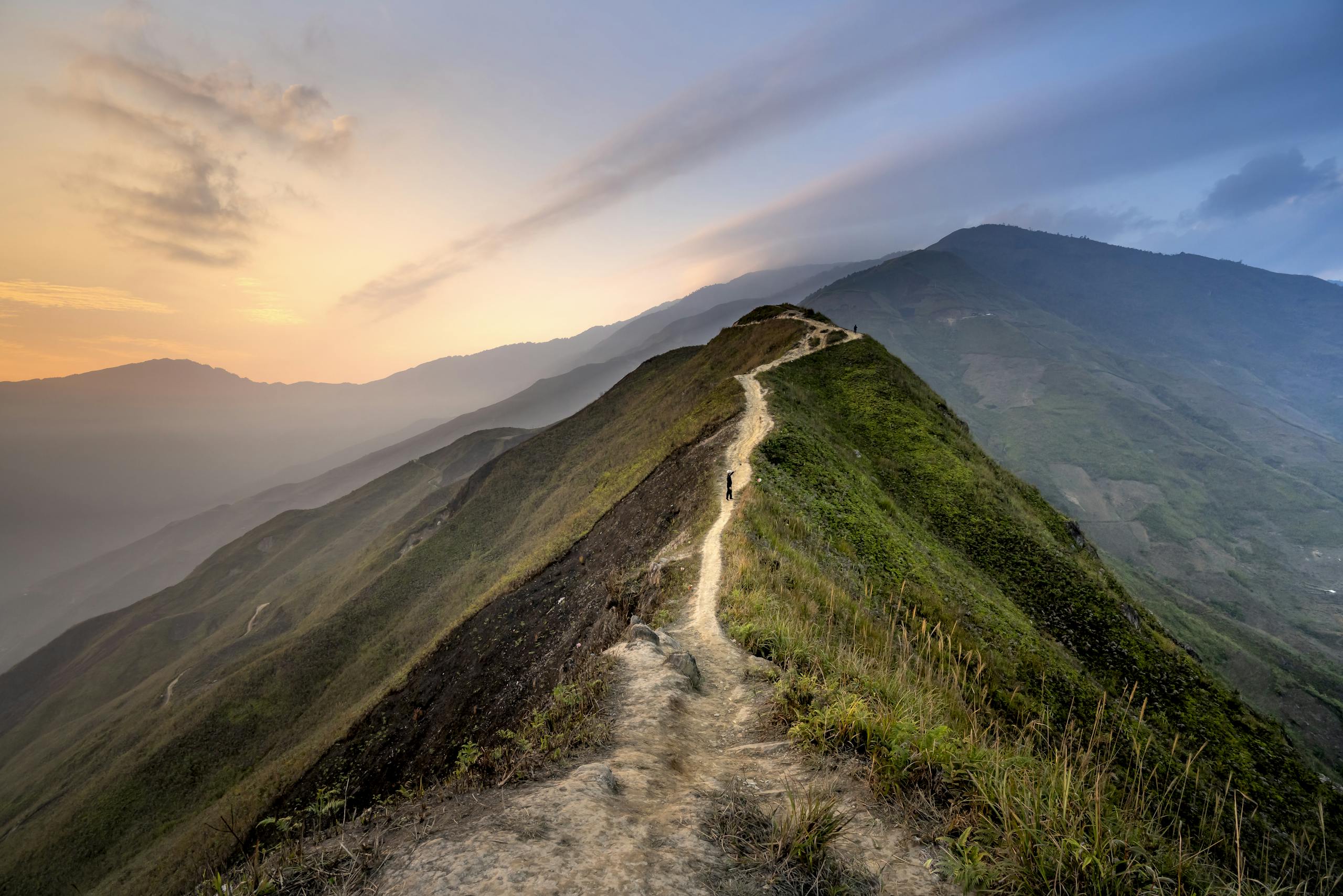 A tranquil mountain path with stunning views at twilight, perfect for nature exploration.